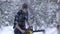 Lumberjack chainsaw manual sawing wood in the winter snowy forest