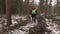 Lumberjack with chainsaw walking in destroyed forest