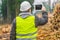 Lumberjack filmed piles of logs with tablet PC in forest