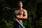 Lumberjack muscled young man. Shirtless athletic naked guy, nature outside.