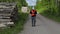 Lumberjack using tablet PC and walking near log of pile