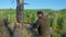 Lumberjack worker chopping down a tree breaking off many splinters in the forest with big axe. Strong healthy adult