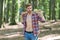 Lumbersexual trend. Bearded man carry axe natural landscape. Sexy guy wear open plaid shirt with masculine look