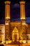 luminated twin minarets of the historical Cifte Minareli Medrese at night or Twin Minaret Madrasa .