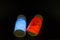 Luminescent organic materials in the form of a powder inside a two glass bottles.
