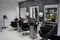 Luminous interior of a beauty salon with three armchairs set up in front of mirrors