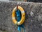 A luminous life saving ring and buoyancy hangs on the harbor wall in Ballintoy on the North Coast of Ireland