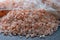 Lump of pink Himalayan salt and a bunch of large crystals of crushed edible Himalayan salt