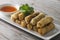 Lumpia Spring Rolls on Wooden Table in Restaurant