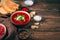 Lunch with borscht with sour cream and garlic on a natural wooden background