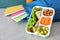 Lunch box with appetizing food and bag on table