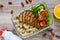 Lunch box: rotini with baked chicken breast and salad on a wooden background. Top view, flat lay.