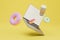 lunch break. a laptop, a glass of coffee and colorful donuts on a yellow background. 3D render