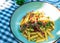 Lunch in the garden, Close up homemade carbonara pasta. Spicy penne pasta cook with dried chilly pepper bacon and arugula top view