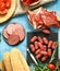Lunch picnic table deli meats sausage, salami, parma, prosciutto bread and vegetables