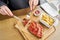 Lunch in a restaurant, a woman cuts Delicious Pork ribs. Full rack of ribs BBQ on wooden plate with french fries and