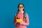 Lunch at school. Smiling teenage girl in glasses holds food in container and apple