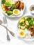 Lunch served - stewed vegetables, rice, boiled egg and teriyaki chicken on light background