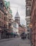 Lund, Sweden - August 4, 2020: A narrow cobblestoned city street in the university town with one of the cathedral steeples visible