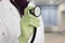 Lung doctor hand in protective glove holding stethoscope