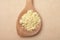 Lupin flour on wooden spoon on brown background