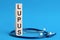 LUPUS word written on wooden blocks and stethoscope on light blue background