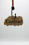 Luring customers and unfair adhesion contract concept: isolated piece of brown old scrap paper hanging on hook, white background