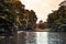 Lush autumn greenery by a refective pond with many parked boats in Burgerpark, Bremen, Germany