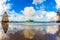 The lush clouds are reflected in sand