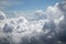 Lush cumulus clouds visible from the aircraft through the porthole