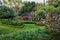 Lush garden with vibrant blooms of various plants and trees.