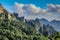 Lush green trees and sharp rocks slope from the top right down to the lower right corner in Huang Shan