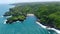 Lush green tropical forest on cliffs and Gesing Beach aerial panorama, Indonesia