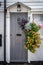 A lush hanging basket next to a grey wooden door