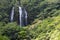 Lush tropical jungle landscape with tall waterfall on the island