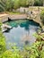 Lush woods surround the bright blue waters of the sinkhole and dive resort at Blue Grotto, Florida