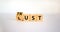 Lust or trust symbol. Turned wooden cubes and changed the words `lust` to `trust`. Beautiful white table, white background.