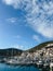 Lustica, Montenegro - 01 november 2023: Sailing yachts stand off the coast with colorful villas at the foot of the