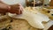 Luthier craftsman sanding a guitar with a little wood planer