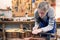 Luthier filing the frets of an acoustic guitar