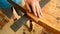 Luthier making the frets of a guitar with a hacksaw