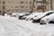 Lutsk, Ukraine - February 12,2020: City street after blizzard. Stuck car in snow and ice. Buried vehicle in snowdrift