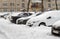 Lutsk, Ukraine - February 12,2020: City street after blizzard. Stuck car in snow and ice. Buried vehicle in snowdrift