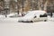 Lutsk, Ukraine - February 12,2020: City street after blizzard. Stuck car in snow and ice. Buried vehicle in snowdrift. Parking in