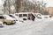 Lutsk, Ukraine - February 12,2020: City street after blizzard. Stuck car in snow and ice. Buried vehicle in snowdrift. Parking in