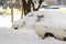 Lutsk, Ukraine - February 12,2020: City street after blizzard. Stuck car in snow and ice. Buried vehicle in snowdrift. Parking in