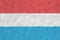 Luxembourg flag depicted in bright paint colors on old relief plastering wall. Textured banner on rough background