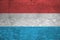 Luxembourg flag depicted in paint colors on old brick wall. Textured banner on big brick wall masonry background
