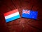 Luxembourg flag with New Zealand flag on a tree stump isolated