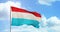 Luxembourg politics and news. Luxembourgish national flag on sky background footage